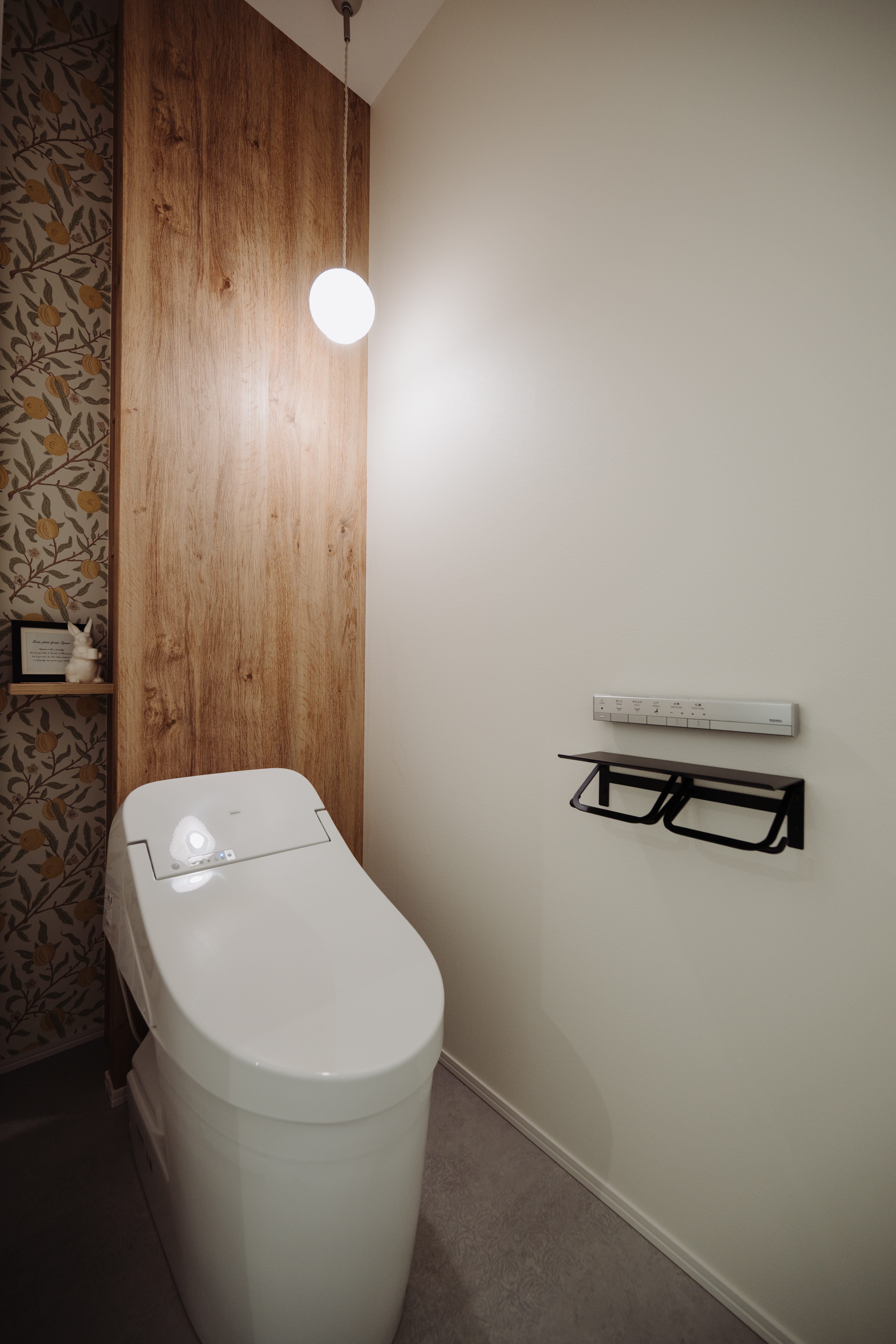 木目調のアクセント壁裏に収納付きのトイレ空間