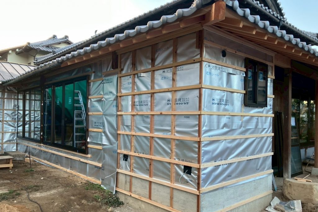 工事中写真_一部増設した壁には防湿・透水シート、外壁下地を施工中。既存建物とつながるよう瓦屋根も葺き替え。