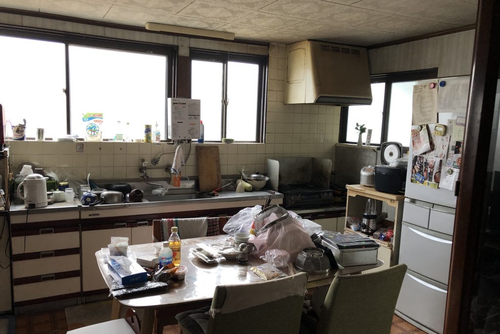 ビフォー写真_天井が低く圧迫感のあるキッチン。物が多く収納が足りていない。