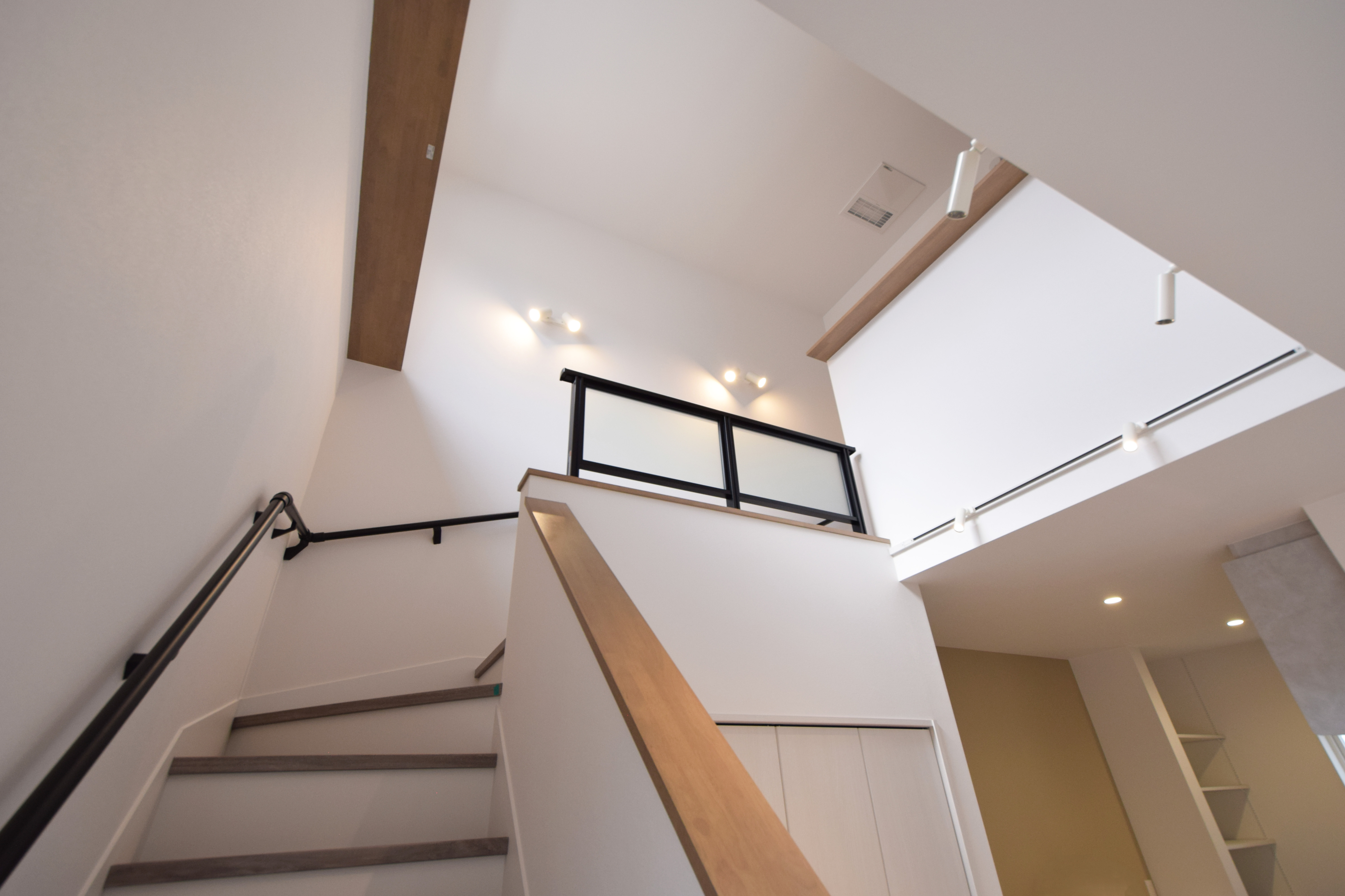 吹き抜けリビング階段。階段下は有効活用して収納を配置。吹き抜けにはキャットウォークを造作。