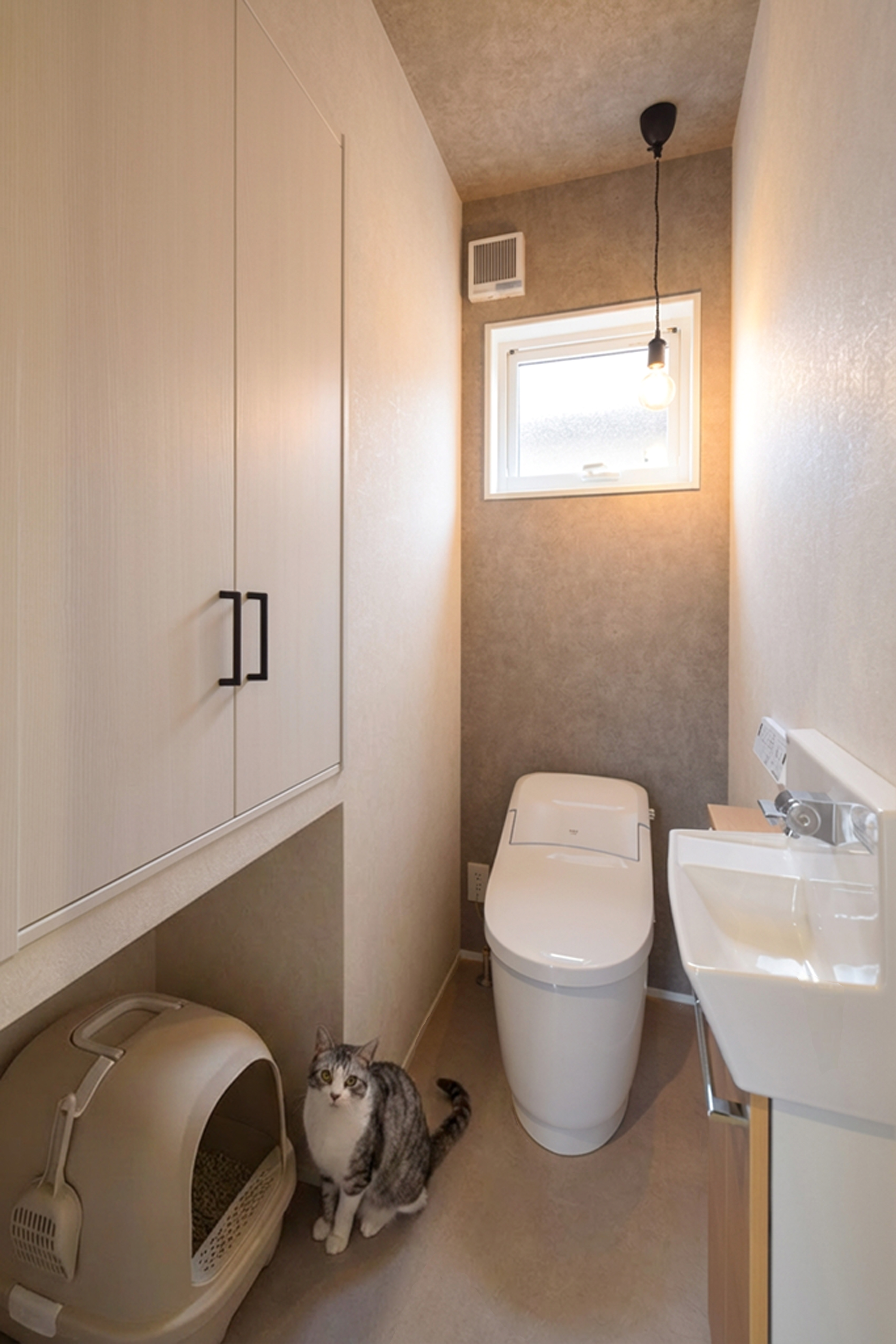 1階トイレに猫用トイレを配置。収納はトイレットペーパーなどの備品に加え、猫砂なども収納できる大容量サイズ。