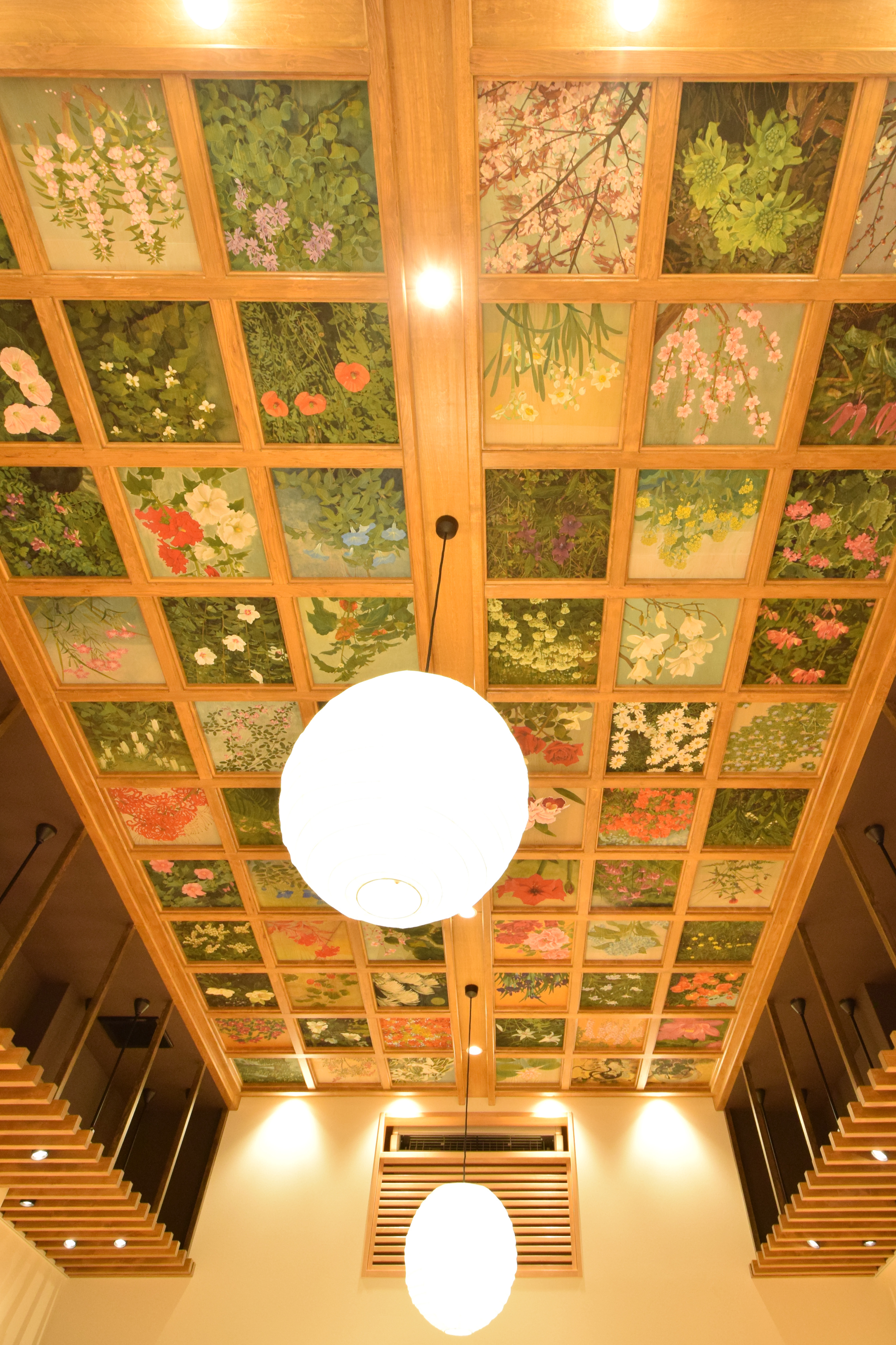 四季の草花が描かれた格天井とペンダント照明のある店舗内装