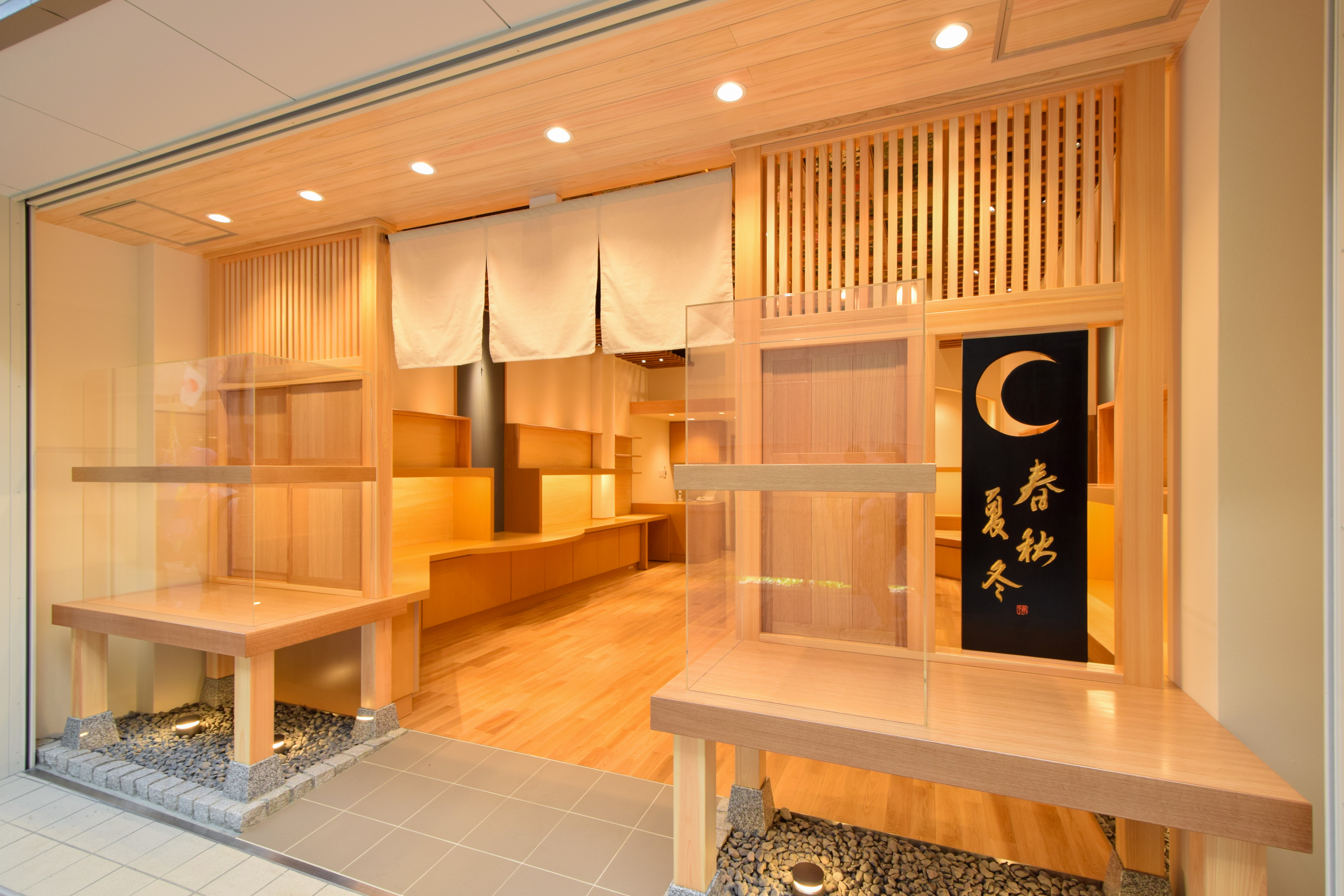 木製格子と大きな開口部を採用した木彫り人形店の店舗正面デザイン