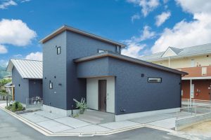ネイビーの外壁と木目の軒天を組み合わせた、1階完結動線のある住まいの外観